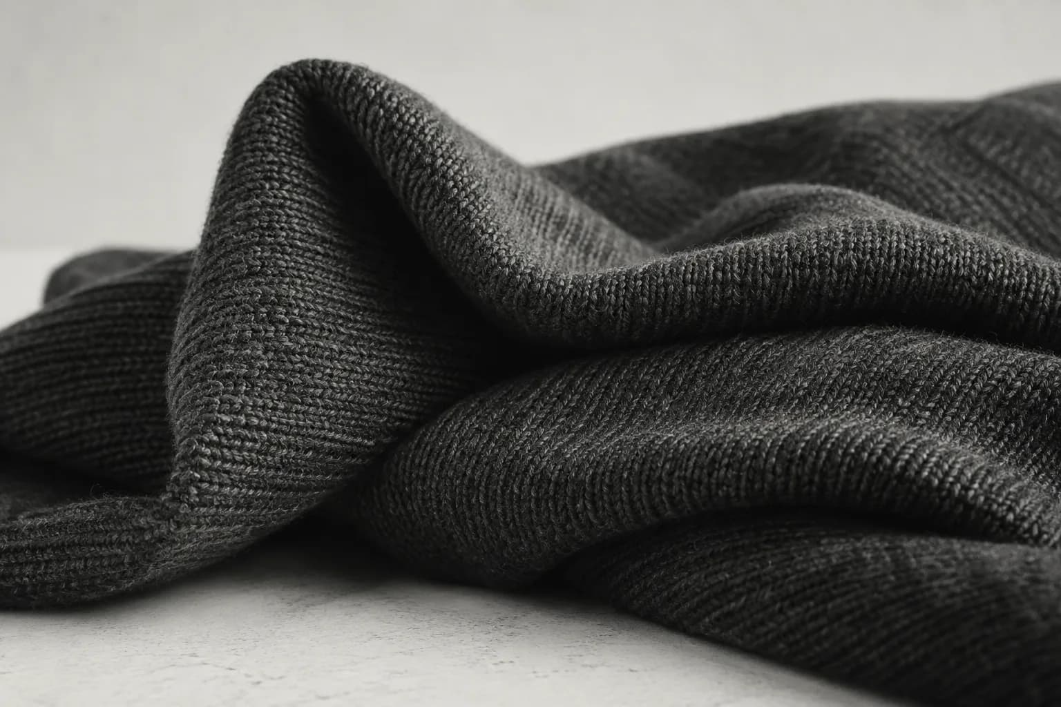 Monochrome material study of folded knit fabric; a visual direction study, not a finished El Patron product.